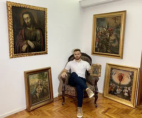 Ignacio Birello surrounding with colonial paintings